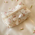 Floral fabric pouch with lace details and a bow on a light background